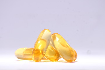 omega 3 fish oil capsule in golden color on white background 
