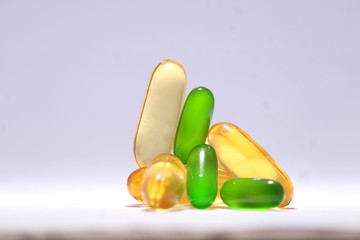 omega 3 fish oil capsule with vitamin E green capsule and vitamin B on white background 