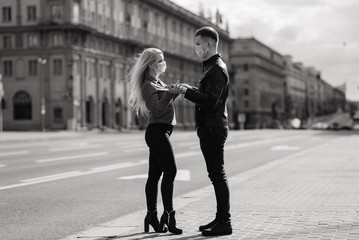 Young couple in masks on city street.