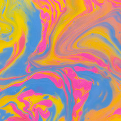 Abstract background of mixed shades of nail polish with a marble pattern. Liquid colorful paint background creative watercolor neon pink, blue, yellow
