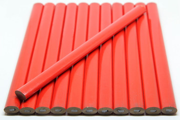 Red carpenter pencil on white background.