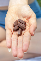 Vitamin B tablets on hand of pretty women or girl.