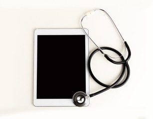 Shot of a stethoscope lying on top of a tablet with copy space against white background