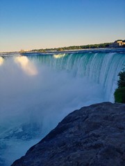 A photo od Niagara falls from Canadian site with rock and blue sky