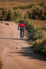 Ciclista en solitario haciendo deporte en camino rural