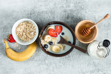 cereal and various delicious ingredients for breakfast and a grey background, top view horizontal