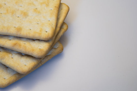 Stack of cream crackers on a white background with copy space