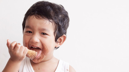 Little boy eating ice cream at home kid has dirty mouth with chocolate summer time concept. 