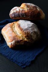 Dark mood and tone Home Cooking Homemade Organic rustic Sourdough bread on black background with copy space