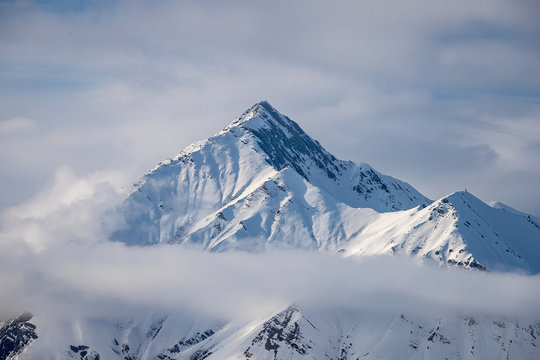 Beautiful snowy mountain peak of the Caucasus mountains in the clouds