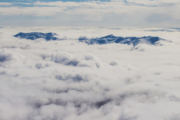 Gray sea from the clouds from which peaks peep