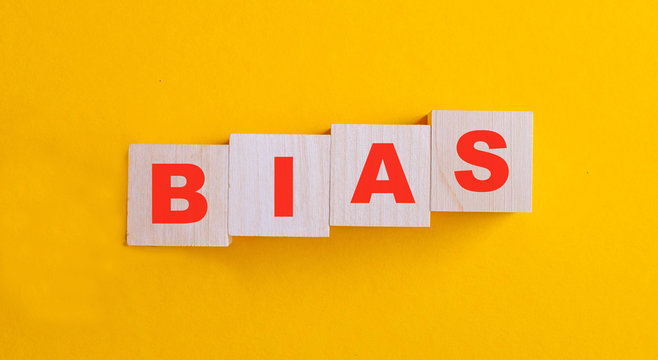 The word bias written in red letters on a yellow background on wooden cubes