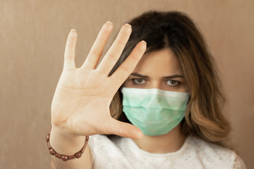 Stop the virus and epidemic diseases. Healthy woman in blue medical protective mask showing gesture