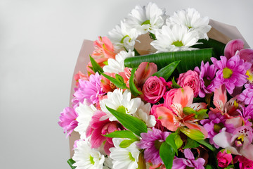 Colorful bouquet of mixed flowers on a gray background. Close-up.