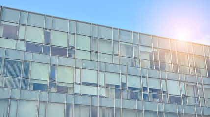 Fototapeta na wymiar Glass building with blue sky background. Modern office building detail, glass surface clouds reflected in windows of modern office building.