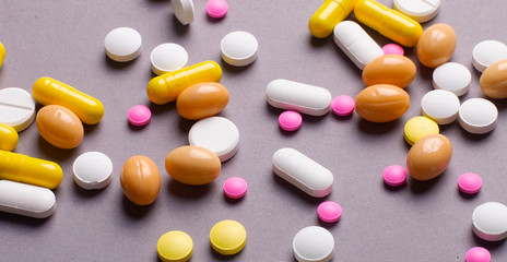 Pile of various colorful pills isolated on gray