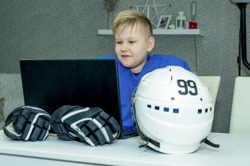 The young hockey player is studying remotely. Theoretical lessons on the Internet. The hockey...