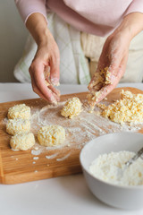 Woman making homemade cheese pancake for breakfast. Girls hands in flour. Cooking fresh healthy food. Preparation raw ingredients for baking. Chef kneading on kitchen table. Culinary work