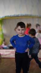 Portrait of cute boy in blue hirt in kindergarten