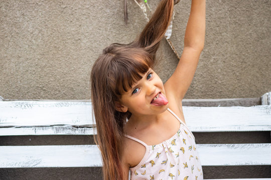 Portrait of little caucasian girl with long hairs fool around and clown