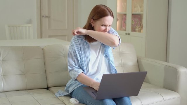 freelancer woman working at computer in apartment. sneezes, coughs and gets sick