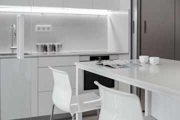 white kitchen, cozy kitchen in the morning to have coffee and read a magazine. plastic chairs. compact kitchen minimalism