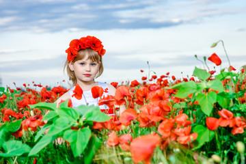 girl in poppy field with a wreath on her head