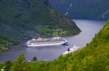 Modern cruiseships or cruise ship liners in Geirangerfjord with panoramic views of Geiranger and...