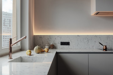 Light kitchen modern style, White walls, marble working surface and wash. Copper crane