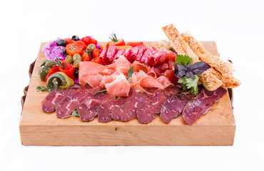 Assorted meat on a wooden board on a white background. Horizontal photo