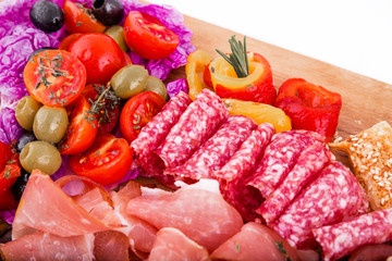 Assorted meat on a wooden board on a white background. Horizontal photo