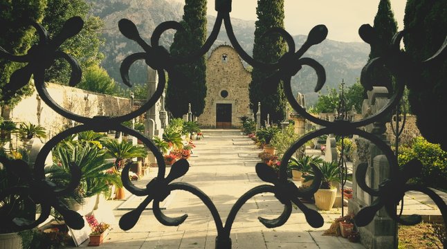 Mediterranean cemetery behind wrought iron gate.