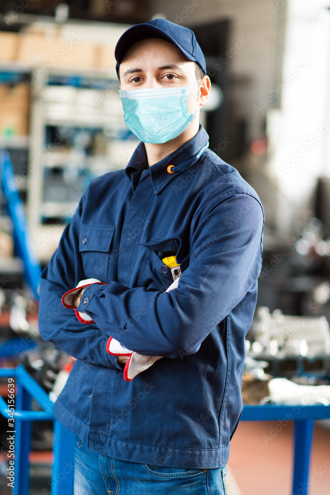 Wall mural Young mechanic portrait wearing a mask - coronavirus concept