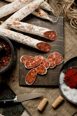 Beef jarky sausage with spices on wooden board with garlic pepper jar wooden texture top