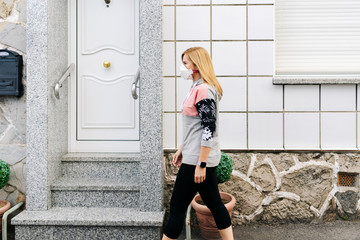 A woman with a mask on her face walks down the street