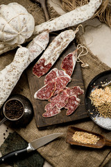 Beef jarky sausage with spices on wooden board with garlic pepper jar wooden texture top