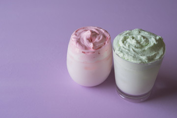 Two glasses of whipped iced milkshake. Dalgona coffee version. Trendy fluffy drink.
