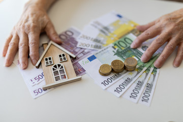 older woman with white hair and money on her hands