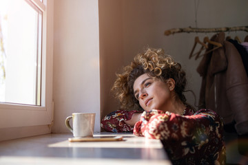 Pensive woman in front of the window
