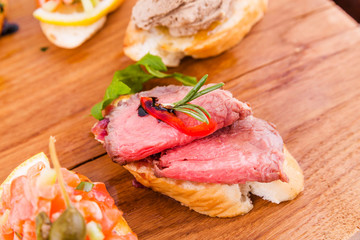 Assorted bruschett on a wooden board on a white background