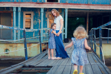 Obraz premium mom and kids in blue clothes standing old bridge