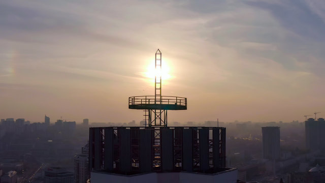 silhouette of a roof spire, lightning rod in a skyscraper. against the backdrop of sunset and evening city center