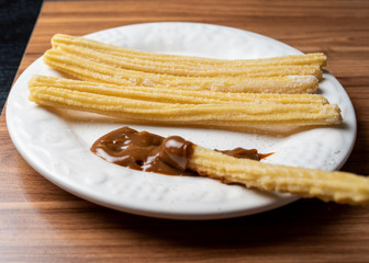 Churros With  Milk Sweet  IN WHITE DISH
Dulce de leche