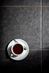 Obraz na płótnie Canvas cup of black filter coffee on the floor daylight sunlight morning coffeebreak spoon