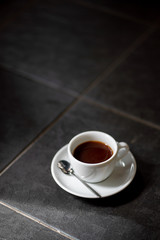 cup of black filter coffee on the floor daylight sunlight morning coffeebreak spoon