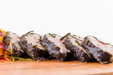 Oriental style pike perch with salmon and julienne of celery and citrus on a wooden board