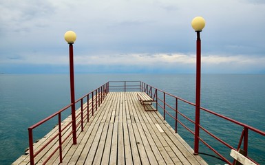 Naklejka premium wooden pier on the lake in cloudy weather