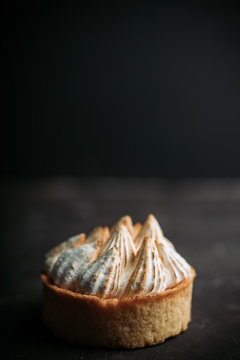 Creamy cake decorated with meringue cream on the rustic background. Selective focus. Shallow depth of field.