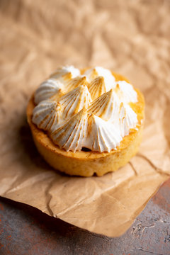 Creamy cake decorated with meringue cream on the rustic background. Selective focus. Shallow depth of field.