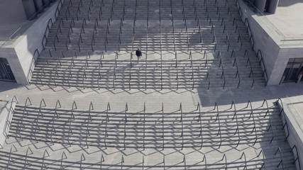 man rises up. top shot from the copter to the big stairs to the stadium. symmetrical linear and...